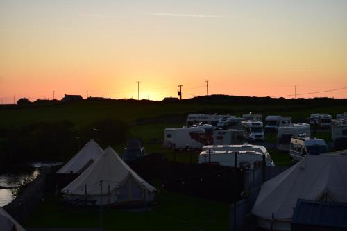 a group of vehicles parked in a parking lot at sunset at Doolin Glamping in Doolin