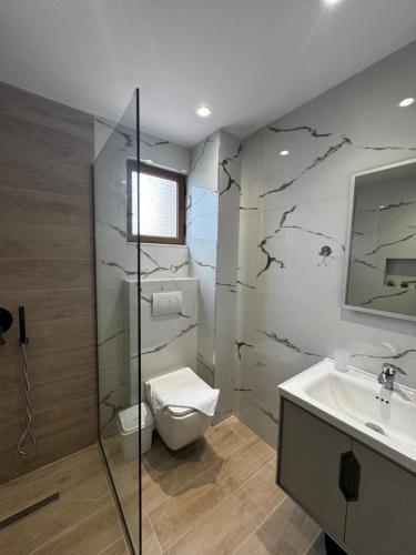 a bathroom with a toilet and a sink at Vila Spiro in Ksamil