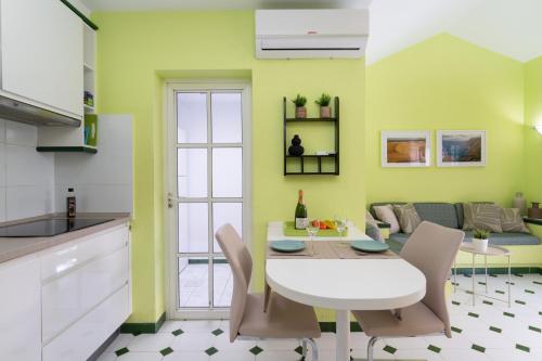 eine Küche und ein Wohnzimmer mit einem weißen Tisch und Stühlen in der Unterkunft Bungalow Angelika Campo Golf in San Bartolomé de Tirajana