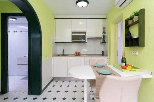 eine Küche mit weißen Schränken und einem Tisch und Stühlen in der Unterkunft Bungalow Angelika Campo Golf in San Bartolomé de Tirajana