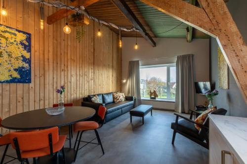a living room with a table and a couch at Welcome in - Appartementen Pleinzicht, met zonnige balkon I Dorpsplein 6 Koudekerke in Koudekerke