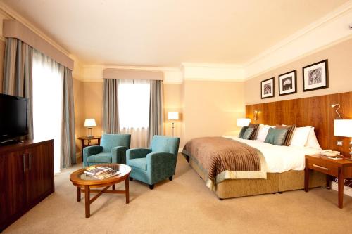 a hotel room with a bed and two chairs and a television at The Grand, York in York