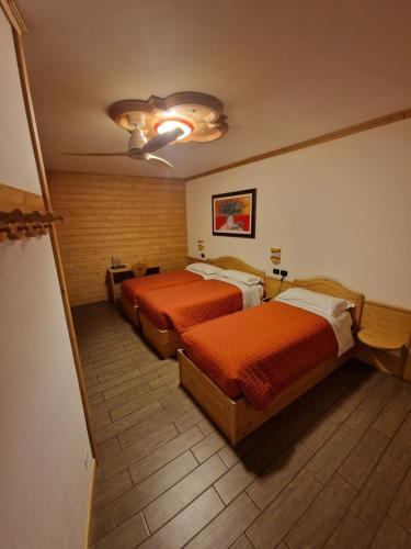 a hotel room with two beds and a ceiling at Hotel Raibl e Appartamenti in Tarvisio