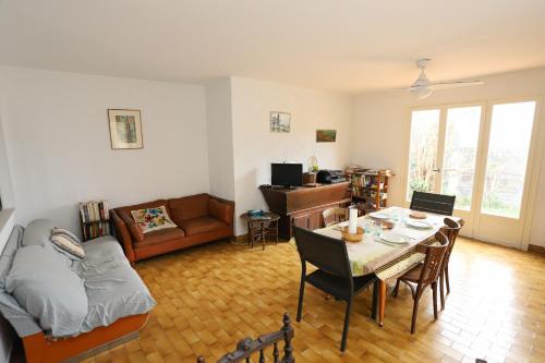 un salon avec une table et un canapé dans l'établissement St Cyprien grande maison familiale proche plage, à Saint-Cyprien