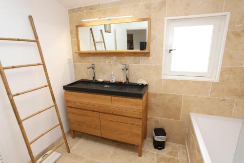 une salle de bain avec un lavabo et un miroir dans l'établissement St Cyprien grande maison familiale proche plage, à Saint-Cyprien