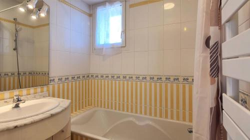 ein Badezimmer mit Badewanne und Waschbecken in der Unterkunft la perle de lecume in Quiberon