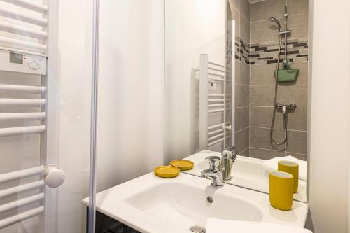 une salle de bain blanche avec un lavabo et une douche dans l'établissement Studio proche université et commodités, à Angers
