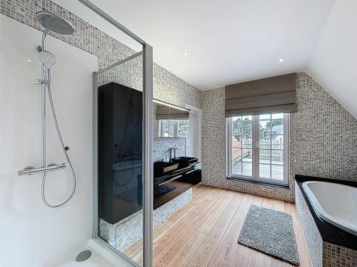 a bathroom with a shower and a sink and a tub at Villa Charme - Koksijde in Koksijde