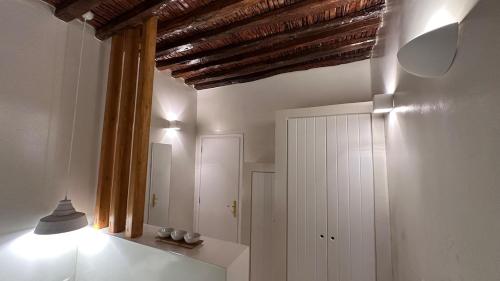 a bathroom with a mirror and a ceiling with beams at Amerissas studios 3 in Skiros