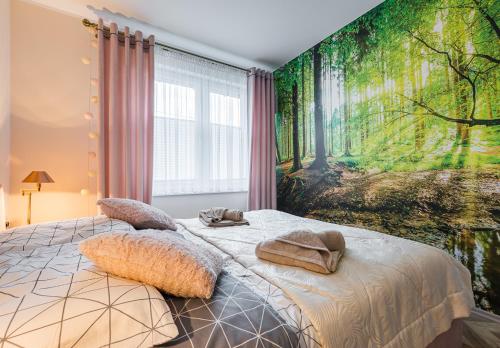 a bedroom with a bed with a forest mural on the wall at Słoneczna Wetlina - Apartament 2 z kominkiem in Wetlina