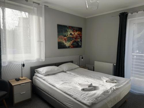 a bedroom with a bed and a painting on the wall at Apartamenty Wczasowa - z widokiem na góry, parkingiem, rowerownią in Kudowa-Zdrój