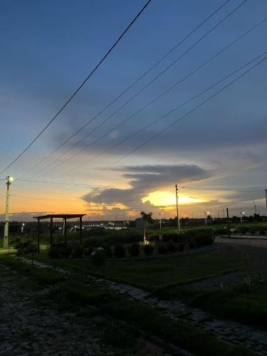 a sunset over a field with the sun setting at Casa Duplex com Piscina próximo praia flecheiras in Trairi