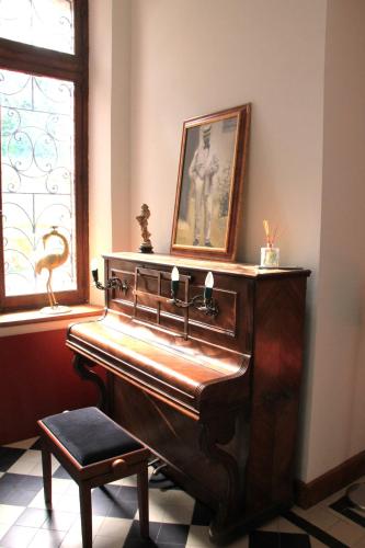 a piano in a room with a picture on the wall at DOMAINE DE LA TISNERE in Gelos