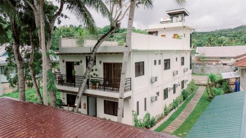 an external view of a building with palm trees at Loboc Riverside Inn & Restaurant in Loboc