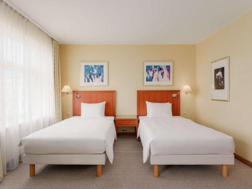 a hotel room with two beds and a window at Radisson Blu Ridzene Hotel, Riga in Rīga