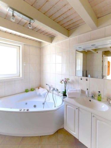 a large white bathroom with a tub and a sink at Ferienpark Bad Saarow in Bad Saarow