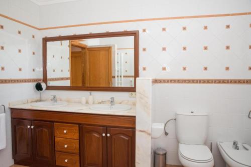 a bathroom with two sinks and a toilet and a mirror at Villa Vernissa 10p in Santa Margalida