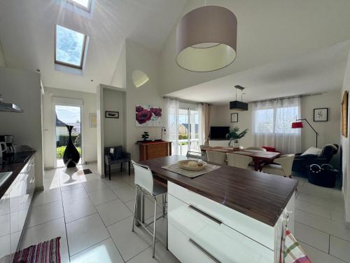 une cuisine et un salon avec une table et des chaises dans l'établissement La Maison des Agapanthes - accès PMR - à 20 mn des Plages, à Pluguffan