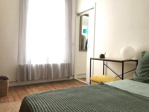 - une chambre avec un lit et une fenêtre avec un miroir dans l'établissement Charming 3-room apartment, Paris center, à Paris