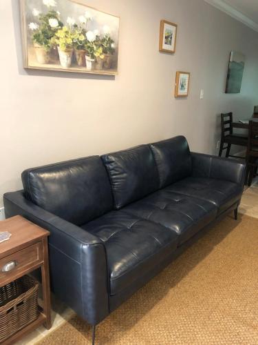 a black leather couch in a living room at 2 br washer dryer Near LSU Tiger Stadium in Baton Rouge