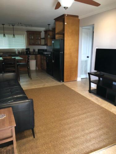 a living room with a black refrigerator and a kitchen at 2 br washer dryer Near LSU Tiger Stadium in Baton Rouge