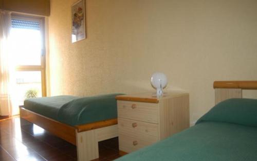 Un dormitorio con dos camas individuales y una cómoda. en serra alimini 2, en Otranto