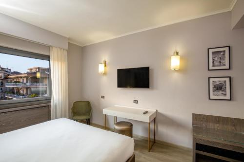 a hotel room with a bed and a desk and a tv at Hotel Marc'Aurelio in Rome