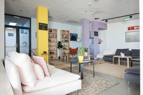 a living room with a white couch and tables at Hotel Ola - Adults Only in Trogir