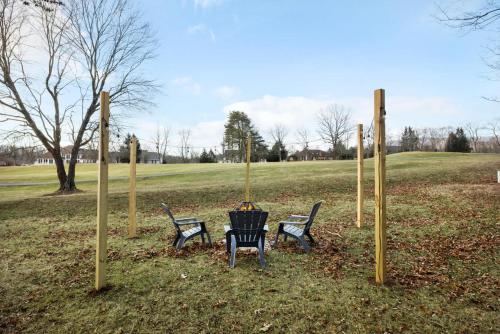 a group of four benches in a park at Golf Views Fireplace 2 Fire Pits Grill & Deck in Hedgesville