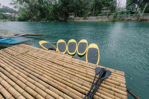 a dock with yellow and white oars on the water at Loboc Riverside Inn & Restaurant in Loboc