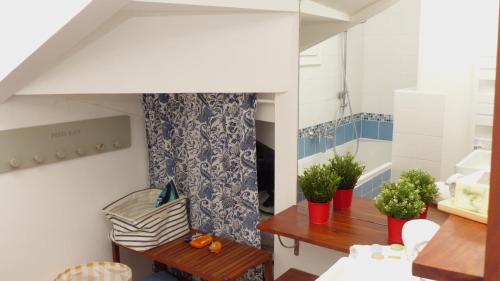 une salle avec deux bancs et une table avec des plantes dans l'établissement Agreable maison de vacances proche des plages, à La Trinité-sur-Mer