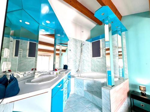 La salle de bains bleue est pourvue de 2 lavabos et d'une baignoire. dans l'établissement Villa Elegance - Piscine - Jardin - Moderne TopProsConciergerie, à Fabrègues