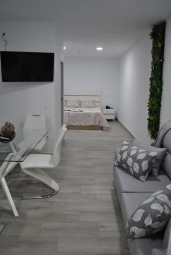 a living room with a couch and a glass table at Viviendas de Uso Turístico Noble Hidalgo TOLEDO in Toledo