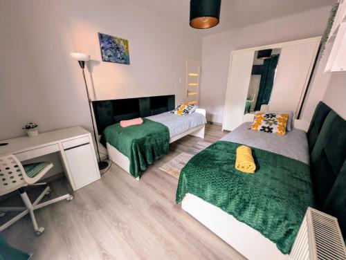 Un dormitorio pequeño con dos camas y un escritorio. en Apartament Zielony Krakowskie Przedmieście 26/2, en Lublin
