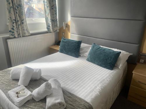 a bedroom with a bed with towels on it at The Wildings Hotel & Tudno's Restaurant in Llandudno