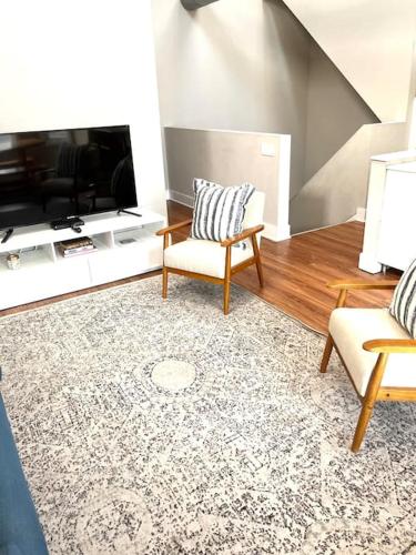 a living room with two chairs and a flat screen tv at Beautiful Unit CHI in Prime River North - top floor in Chicago