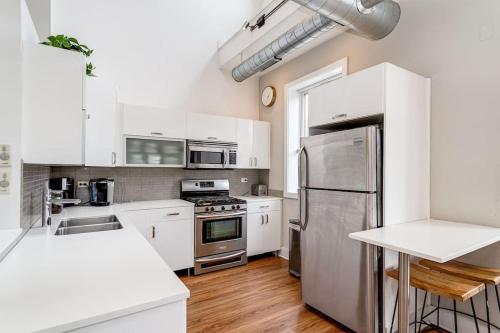 a kitchen with white cabinets and a stainless steel refrigerator at Beautiful Unit CHI in Prime River North - top floor in Chicago