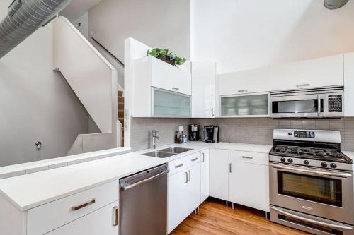 a kitchen with white cabinets and stainless steel appliances at Beautiful Unit CHI in Prime River North - top floor in Chicago
