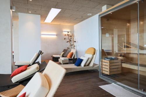 a living room with a white couch and chairs at Hotel Ola - Adults Only in Trogir