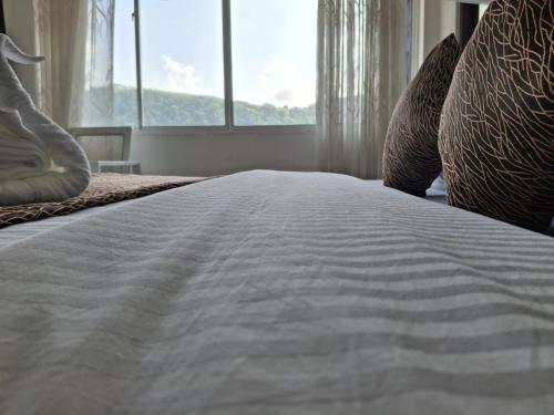 a large white bed with pillows and a window at Dew Drops Nature Villa in Parakaduwa