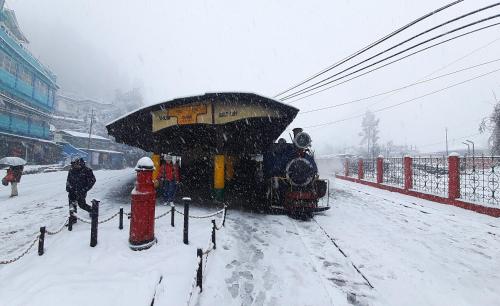a train on a track in the snow at Norchuk Homestay in Jālāpahār