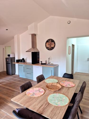 d'une cuisine avec une table en bois et 4 assiettes. dans l'établissement Spacieux T3, Résidence Charles Trenet, à Narbonne