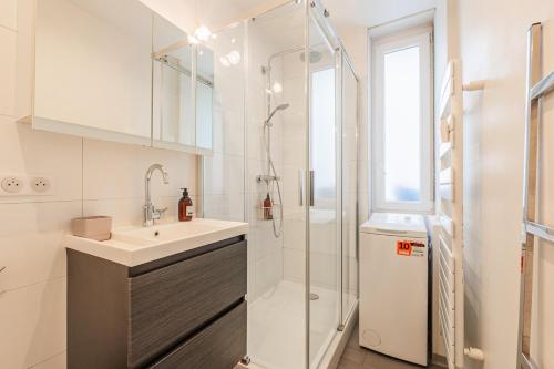une salle de bain avec un lavabo et une douche dans l'établissement Le Kléber - Appt en hypercentre, proche Place Kléber, à Strasbourg