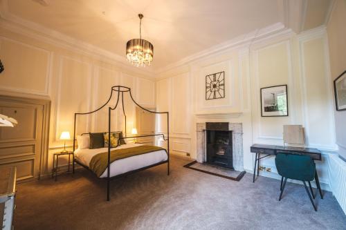 a bedroom with a bed and a fireplace and a desk at The Chapel Suite in Marske