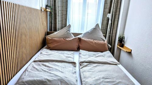a bed in a room with pillows and a window at Meissen Apartments - moderne Ferienwohnungen in Meißen am Lutherplatz in Meißen