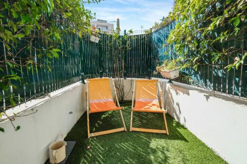 deux chaises assises sur l'herbe à côté d'une clôture dans l'établissement A027 - Appartement moderne - Près de la plage, à Antibes