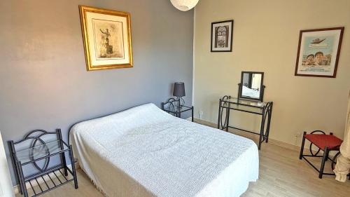 - une chambre avec un lit et une table avec un miroir dans l'établissement Bosquets, à Sainte-Maxime