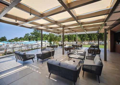 an outdoor patio with couches and tables and chairs at Camping Park Umag - Eurocamp I Homair in Umag