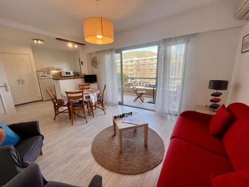 un salon avec un canapé rouge et une table dans l'établissement Appartement 3 pièces à Cavalaire-sur-Mer, proche plage avec parking - FR-1-226B-76, à Cavalaire-sur-Mer