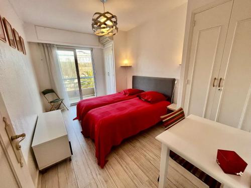 - une chambre avec un lit rouge et une fenêtre dans l'établissement Appartement 3 pièces à Cavalaire-sur-Mer, proche plage avec parking - FR-1-226B-76, à Cavalaire-sur-Mer